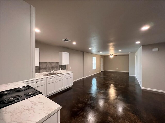 360507 Park Blvd, Chalmette, LA 70043 - kitchen featuring decorative backsplash, light countertops, recessed lighting, finished concrete floors, and white cabinets