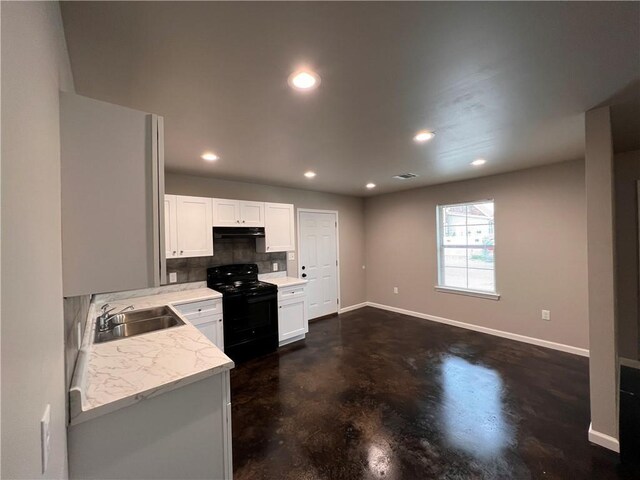 360507 Park Blvd, Chalmette, LA 70043 - kitchen with black electric range, finished concrete flooring, under cabinet range hood, white cabinets, and recessed lighting