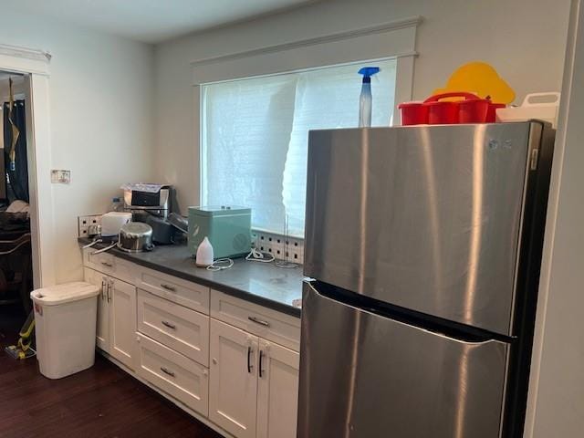 7109 Dreux Ave, New Orleans, LA 70126 - kitchen featuring freestanding refrigerator, dark wood-style floors, white cabinets, and dark countertops
