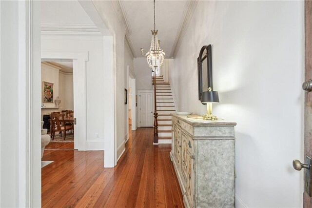 1128 Fourth St, New Orleans, LA 70130 - hallway featuring a chandelier, ornamental molding, dark wood-style flooring, and stairway