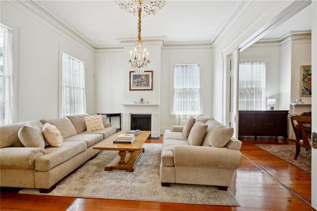 1128 Fourth St, New Orleans, LA 70130 - living room featuring a chandelier, wood-type flooring, a fireplace, and crown molding