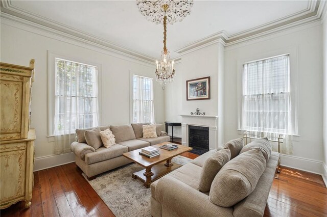 1128 Fourth St, New Orleans, LA 70130 - living room with a chandelier, dark wood-type flooring, crown molding, and a fireplace with flush hearth