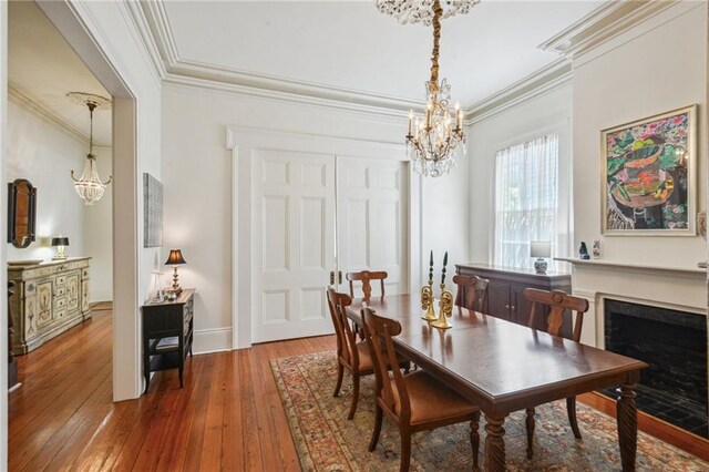 1128 Fourth St, New Orleans, LA 70130 - dining area featuring a chandelier, crown molding, hardwood / wood-style floors, and a fireplace with flush hearth