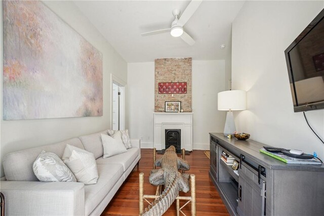 1128 Fourth St, New Orleans, LA 70130 - living room featuring dark wood-style flooring, a ceiling fan, and a fireplace