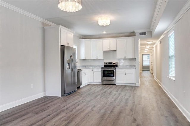 1704-1706 S Dupre St, New Orleans, LA 70125 - kitchen with stainless steel appliances, white cabinets, light wood finished floors, ornamental molding, and a chandelier