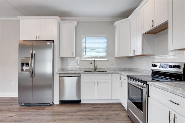 1704-1706 S Dupre St, New Orleans, LA 70125 - kitchen with stainless steel appliances, white cabinetry, light wood-style flooring, ornamental molding, and backsplash