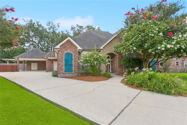 142 Colony Rd, Belle Chasse, LA 70037 - view of front of property with concrete driveway, brick siding, and a carport