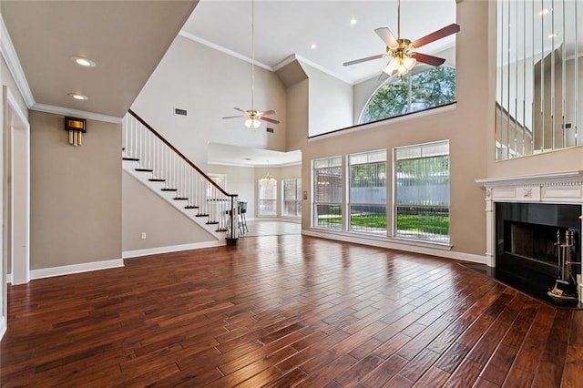 142 Colony Rd, Belle Chasse, LA 70037 - unfurnished living room featuring a ceiling fan, wood finished floors, ornamental molding, stairs, and a fireplace