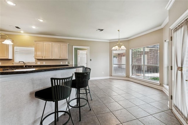 142 Colony Rd, Belle Chasse, LA 70037 - kitchen with a chandelier, a kitchen breakfast bar, dark countertops, light tile patterned floors, and hanging light fixtures