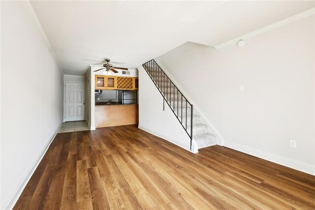3805 Houma Blvd Unit B221, Metairie, LA 70006 - unfurnished living room with ornamental molding, a ceiling fan, wood finished floors, and stairway