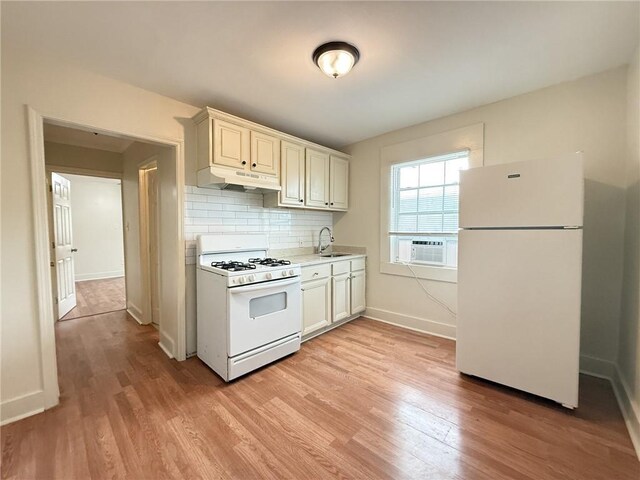 134648 S Dilton St, Metairie, LA 70003 - kitchen featuring white appliances, under cabinet range hood, light wood-style flooring, and backsplash