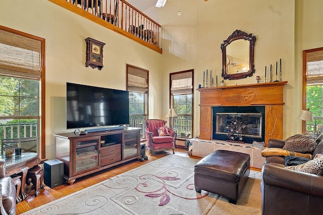 126 Gemstone Dr, Franklinton, LA 70438 - living room featuring a glass covered fireplace, wood finished floors, a high ceiling, and a ceiling fan