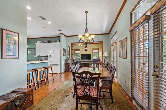 126 Gemstone Dr, Franklinton, LA 70438 - dining area with crown molding, a chandelier, a textured ceiling, recessed lighting, and light wood-type flooring