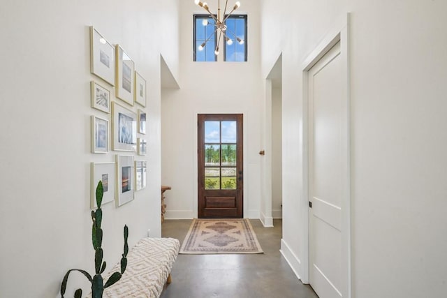 52554 Shore Dr, Franklinton, LA 70438 - entryway featuring a chandelier, concrete floors, and a towering ceiling