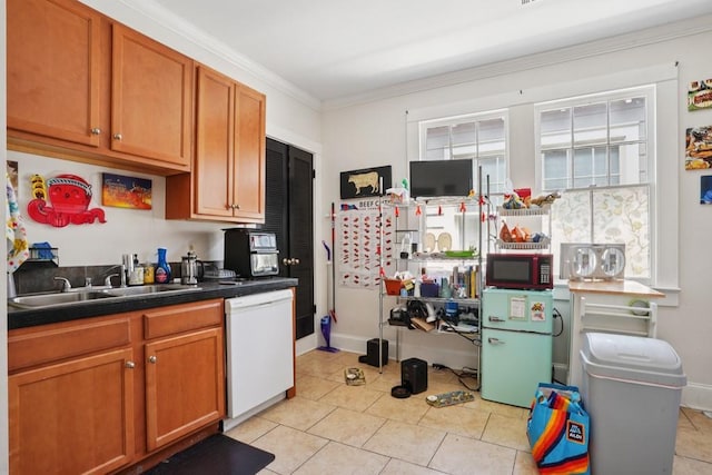 432426 Banks St, New Orleans, LA 70119 - kitchen featuring dishwasher, crown molding, light tile patterned floors, freestanding refrigerator, and dark countertops