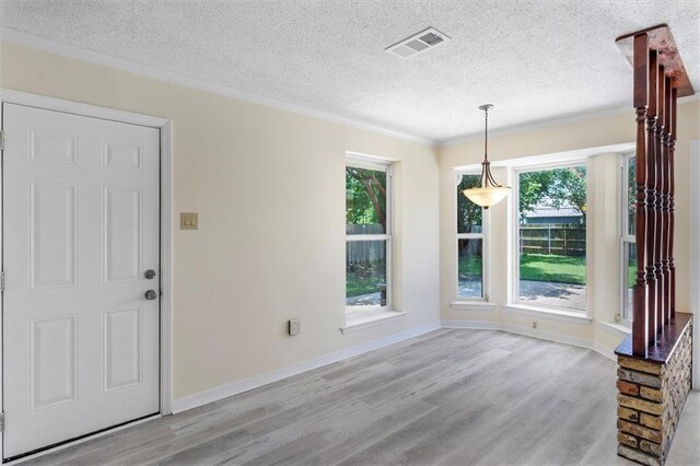 4013 Taft Park, Metairie, LA 70002 - unfurnished dining area with wood finished floors, crown molding, a textured ceiling, and healthy amount of natural light