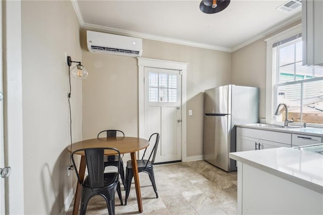 62426 9th St, New Orleans, LA 70115 - kitchen with a wall mounted air conditioner, freestanding refrigerator, crown molding, plenty of natural light, and light countertops