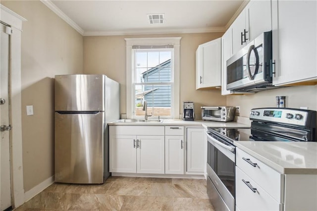 62426 9th St, New Orleans, LA 70115 - kitchen with stainless steel appliances, crown molding, white cabinetry, and light countertops