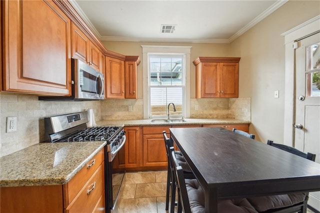 62426 9th St, New Orleans, LA 70115 - kitchen featuring appliances with stainless steel finishes, brown cabinetry, ornamental molding, tasteful backsplash, and light stone counters