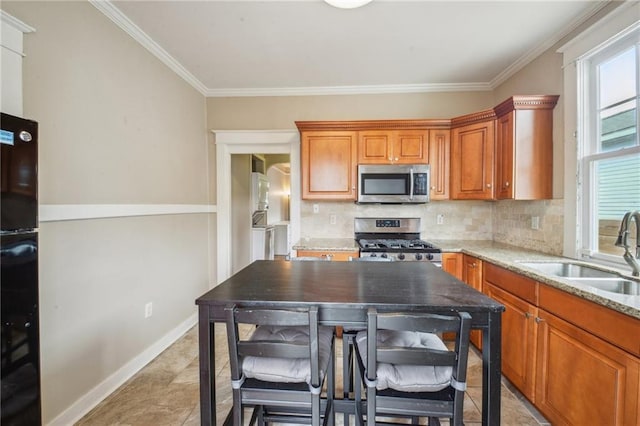 62426 9th St, New Orleans, LA 70115 - kitchen featuring appliances with stainless steel finishes, tasteful backsplash, brown cabinets, ornamental molding, and light stone countertops