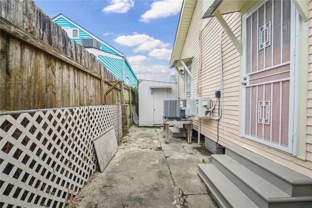 62426 9th St, New Orleans, LA 70115 - view of side of property with a patio area, entry steps, a fenced backyard, and a storage shed