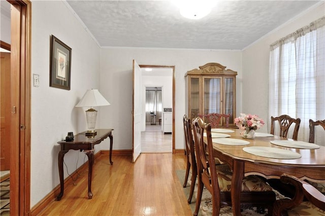 2727 Carondelet St, New Orleans, LA 70130 - dining area featuring a textured ceiling, light wood-type flooring, and crown molding