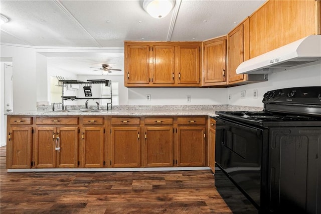 564 Mathew St, Lafitte, LA 70067 - kitchen with black / electric stove, under cabinet range hood, ceiling fan, brown cabinets, and dark wood-style flooring