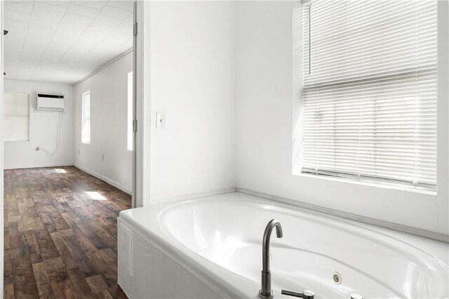 564 Mathew St, Lafitte, LA 70067 - bathroom featuring a jetted tub, wood finished floors, and a wall mounted AC