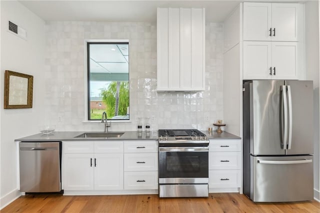 810 N Roman St, New Orleans, LA 70116 - kitchen featuring stainless steel appliances, white cabinets, and backsplash