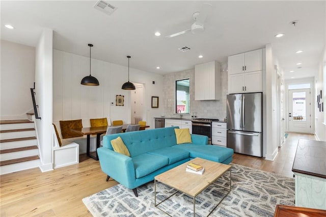 810 N Roman St, New Orleans, LA 70116 - living room featuring light wood-style flooring, stairway, and recessed lighting