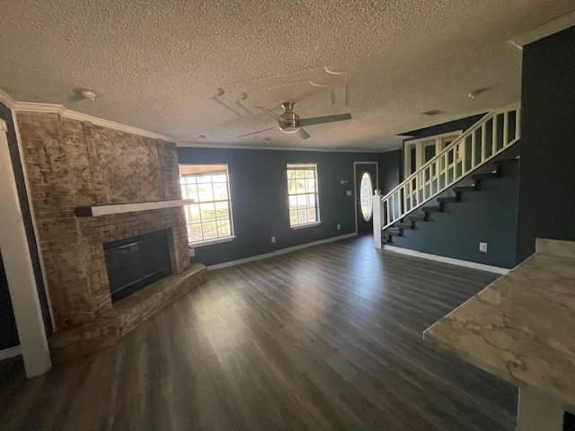 14151 W Hoffman Rd, Hammond, LA 70403 - unfurnished living room with a textured ceiling, ornamental molding, ceiling fan, wood finished floors, and a brick fireplace