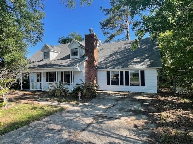 14151 W Hoffman Rd, Hammond, LA 70403 - cape cod house featuring a porch, a chimney, and driveway