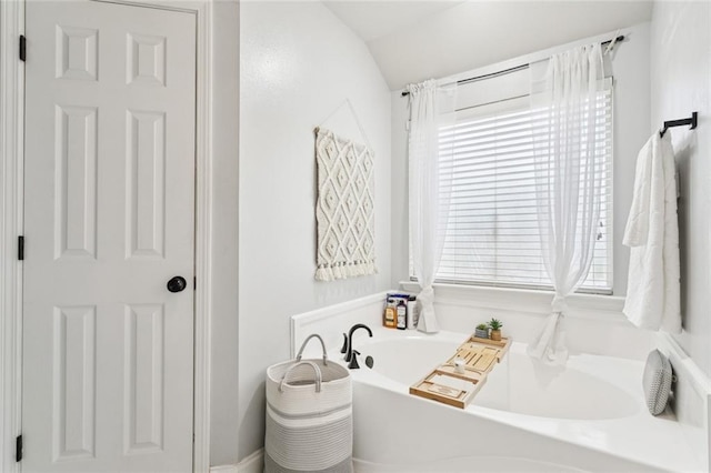 2311 Jay St, Slidell, LA 70460 - bathroom featuring a bath, healthy amount of natural light, and vaulted ceiling