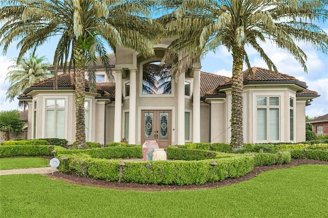 154 Primrose Dr, Belle Chasse, LA 70037 - view of front facade with french doors, a tile roof, stucco siding, and a front lawn