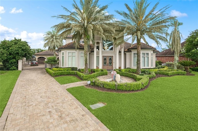 154 Primrose Dr, Belle Chasse, LA 70037 - mediterranean / spanish house with a tiled roof, french doors, a front lawn, and stucco siding