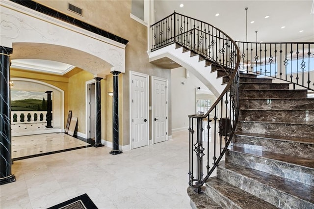 154 Primrose Dr, Belle Chasse, LA 70037 - stairs featuring arched walkways, marble tiled floors, a towering ceiling, decorative columns, and recessed lighting