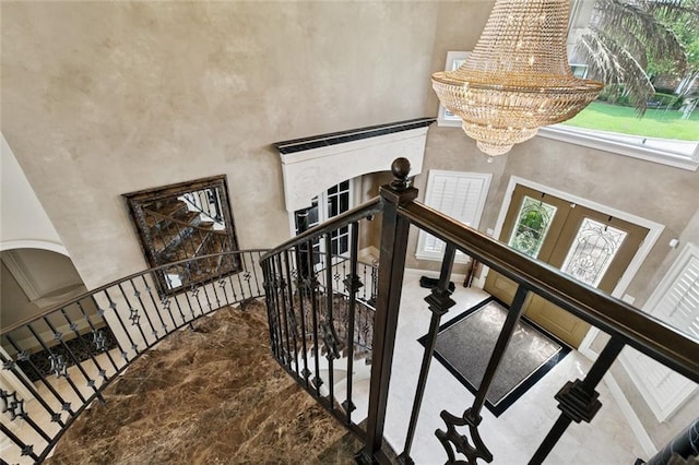 154 Primrose Dr, Belle Chasse, LA 70037 - staircase featuring a towering ceiling, a chandelier, french doors, arched walkways, and healthy amount of natural light