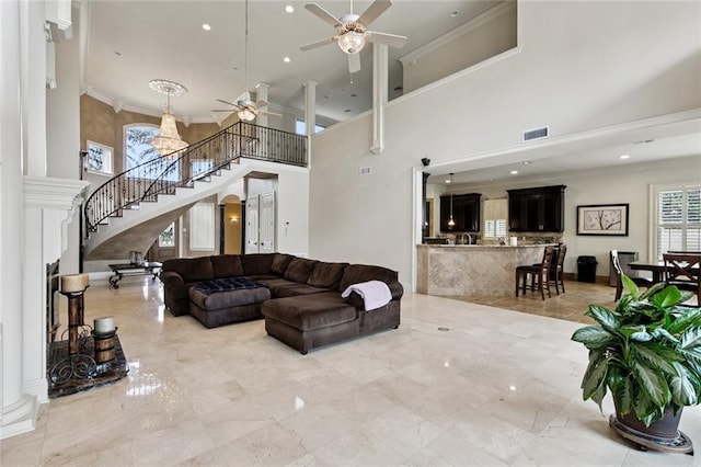 154 Primrose Dr, Belle Chasse, LA 70037 - living room featuring a ceiling fan, a high ceiling, stairway, crown molding, and decorative columns