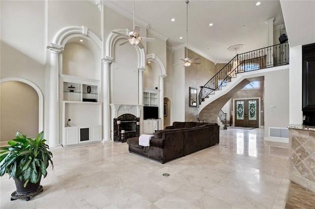 154 Primrose Dr, Belle Chasse, LA 70037 - living area featuring a premium fireplace, a ceiling fan, a high ceiling, built in features, and stairs