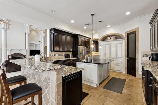 154 Primrose Dr, Belle Chasse, LA 70037 - kitchen with stainless steel fridge with ice dispenser, a breakfast bar area, stone tile floors, a fireplace, and a ceiling fan