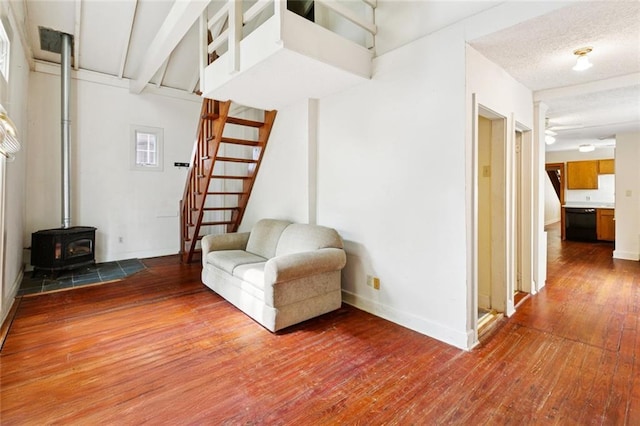 523-25 Spain St, New Orleans, LA 70117 - living area featuring a wood stove, hardwood / wood-style floors, stairway, and a textured ceiling