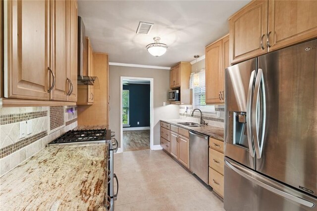1605 Rue Lemans, Slidell, LA 70458 - kitchen with appliances with stainless steel finishes, wall chimney exhaust hood, decorative backsplash, plenty of natural light, and crown molding
