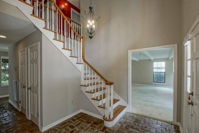 8808 Chretien Point Pl, River Ridge, LA 70123 - stairs featuring brick flooring and a chandelier