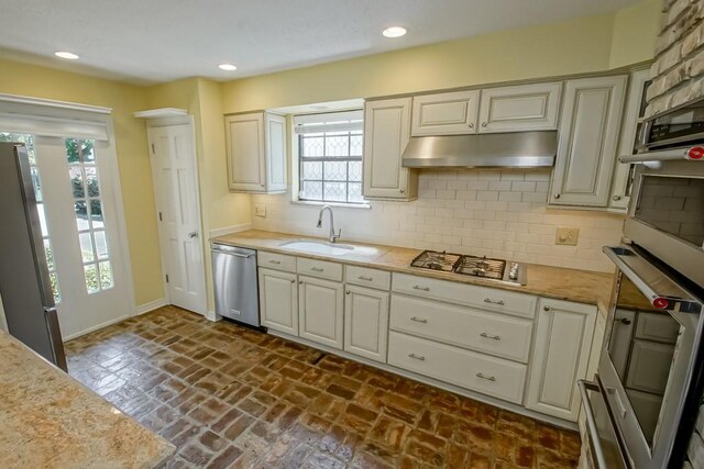8808 Chretien Point Pl, River Ridge, LA 70123 - kitchen with stainless steel appliances, under cabinet range hood, decorative backsplash, healthy amount of natural light, and recessed lighting