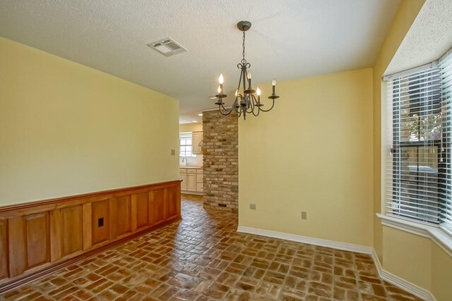 8808 Chretien Point Pl, River Ridge, LA 70123 - empty room with a chandelier, brick floors, and wainscoting