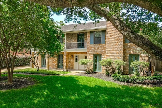 8808 Chretien Point Pl, River Ridge, LA 70123 - view of front of home featuring french doors, a balcony, a front lawn, and brick siding