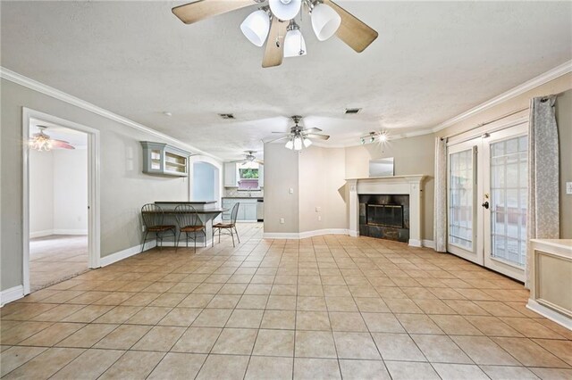 2142 Park Dr, Slidell, LA 70458 - living room with ceiling fan, ornamental molding, light tile patterned floors, healthy amount of natural light, and a glass covered fireplace