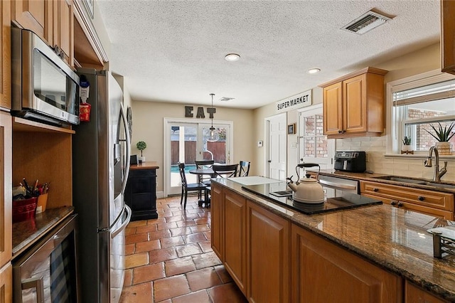 9408 Citrus Ln, River Ridge, LA 70123 - kitchen with stainless steel appliances, plenty of natural light, decorative backsplash, a textured ceiling, and pendant lighting