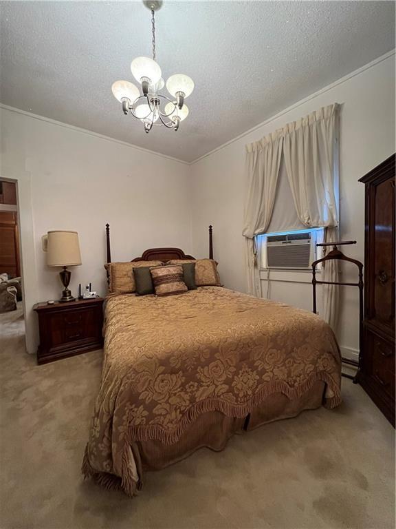 842426 Willow St, New Orleans, LA 70118 - carpeted bedroom featuring a chandelier, a textured ceiling, crown molding, and cooling unit