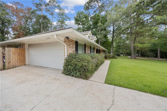 426 Devon Dr, Mandeville, LA 70448 - view of side of property with a yard, an attached garage, driveway, and brick siding